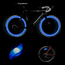 Load image into Gallery viewer, Two LED lights clipped to bicycle spokes, glowing in multiple colours to improve night visibility.