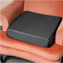 Load image into Gallery viewer, Supportive black seat cushion resting on an armchair, designed to reduce pressure and improve sitting comfort.