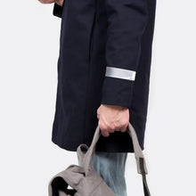 Load image into Gallery viewer, Person wearing a black Bookman reflective slap wrap over dark trousers while carrying a bag outdoors.