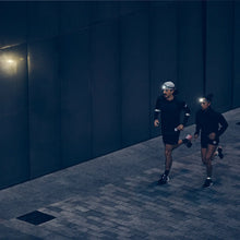 Load image into Gallery viewer, Two runners wearing reflective slap wraps during an outdoor run in low-light conditions.