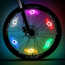 Load image into Gallery viewer, Two LED lights clipped to bicycle spokes, glowing in multiple colours to improve night visibility.