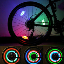 Load image into Gallery viewer, Two LED lights clipped to bicycle spokes, glowing in multiple colours to improve night visibility.