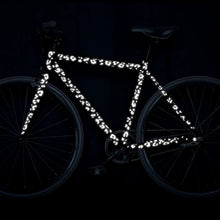 Load image into Gallery viewer, Black reflective leopard stickers applied to a bicycle frame, enhancing visibility in low-light conditions