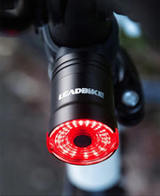 Load image into Gallery viewer, Black replacement mounting bracket attached to a bicycle handlebar, holding CushBike Flare Recon LED light and waterproof powerbank.