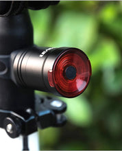 Load image into Gallery viewer, Black replacement mounting bracket attached to a bicycle handlebar, holding CushBike Flare Recon LED light and waterproof powerbank.