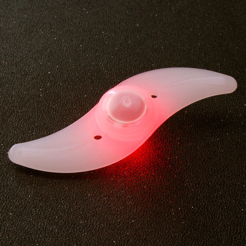 Two LED lights clipped to bicycle spokes, glowing in multiple colours to improve night visibility.
