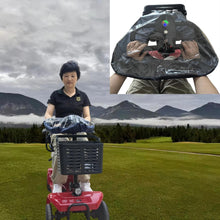 Load image into Gallery viewer, Clear rain cover fitted over a mobility scooter tiller and control panel, showing the rider’s hands operating the controls through the transparent PVC material while traveling outdoors.
