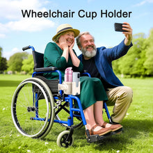 Load image into Gallery viewer, Mobility accessory cup holder mounted on a wheelchair frame, securely holding a drink bottle and phone as a seated user enjoys time outside

