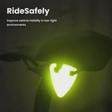 Load and play video in Gallery viewer, Demo video showing high-visibility orange reflective bicycle pendant being attached to a bike and glowing in low light.
