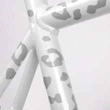Load image into Gallery viewer, Close-up of white reflective leopard-pattern stickers applied to a white bicycle frame.
